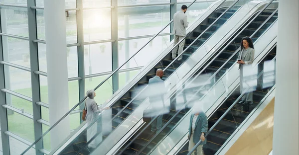 Business people, elevator and travel with office and international trip with lens flare. Corporate, professional on escalator and appointment with conference, stairs for convention and executives.