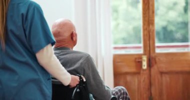 Yaşlı, sabırlı ve hareket kabiliyetine yardımcı olması için yatak odasında tekerlekli sandalyeye itilmiş. Kıdemli adam, hemşire ve tedavi sonrası yardım, iyileşme ya da evde refah için rehabilitasyon.