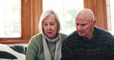 Ev, dizüstü bilgisayar ve yaşlı çiftle belgeler, emeklilik fonu, emeklilik ve yatırımla finansman ve sohbet. Apartman dairesi, yaşlı adam ve yaşlı kadın elinde bilgisayar, evrak ve borç tartışması var..