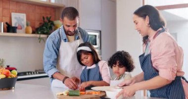 Yemek pişirme, yemek ve çocuklu ebeveynler mutfakta kaynaşıyor ve evde birlikte eğleniyorlar. Mutlu, gülümse ve genç anne ve baba akşam yemeği, akşam yemeği ya da çocuklarla öğle yemeği için öğretmenlik ve hazırlık yapıyor.