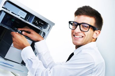 Bilgisayar kulesi, portre ve mutlu adam tamir stüdyosu donanımı, elektronik veya elektrik makinesini kontrol edin. Sistem bakım uzmanı, mutluluk ve bilişim desteği beyaz arkaplandaki teknolojik ekipmanları tamir ediyor.