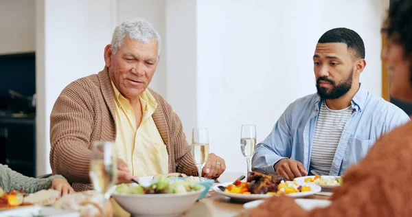 Food, holidays and a family at the dinner table of their home together for eating a celebration meal. Love, thanksgiving and a group of people in an apartment for festive health, diet or nutrition.