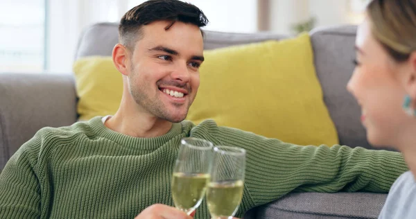Couple, happy man and champagne for cheers in living room for celebration, anniversary and event. Husband, face and smile with spouse for good news with drink, glass and home for sitting on floor.