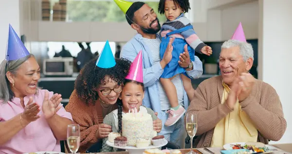 Birthday party, cake and family, children and grandparents with celebration, singing and clapping or applause for love. Happy interracial mom, dad and girl for congratulations and dessert at home.