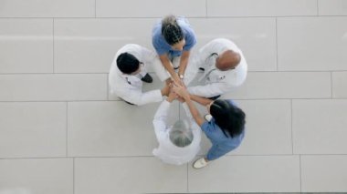 Top view, eller bir arada ve doktorlar motivasyon, işbirliği ve alkışlarla bir hastanede, takım çalışması ve hedefler. Takım oluşturma, klinik görevi ve alkışlaması olan grup, personel veya tıp uzmanları.