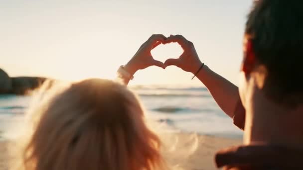 ハート ハンド カップルは サポート 自然へのコミットメントでビーチでズームします ロマンス 絆のための海で絵文字フレームを持つ人々のクローズアップ — ストック動画