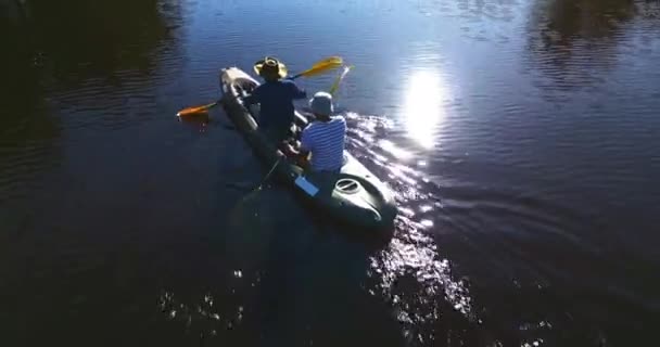 上から自然の中でカヤックの湖 キャンプ 男性と一緒にスポーツや楽しい夏の冒険 ローイングボート カヌーの趣味 そして川の友人たち 日差し 水とアウトドアバケーションの自由 — ストック動画