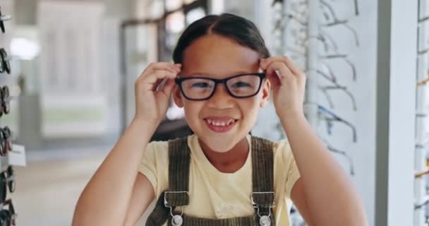幸せな女の子 オプトメトリストのオフィスの修正のためのメガネのための買い物 アイウェアの選択 決定または選択の眼科 レンズまたはフレームのための若者 笑顔および興奮する子供 — ストック動画
