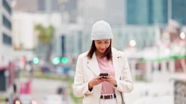 Modayı takip eden şık bir kadın yeni güzel bir şehirde telefon GPS 'i ile geziyor. Genç, kendinden emin ve mutlu bir kadın şehir dışında dolaşırken sosyal medya paylaşımlarını güncelliyor..