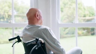 Pencere, düşünce ve tekerlekli sandalyedeki yaşlı adam ve sağlık, emeklilik ve ameliyat endişesi. Huzurevi, akıl sağlığı ve engelli, depresyon ve kederi olan ya da yalnız yaşayan yaşlılar..