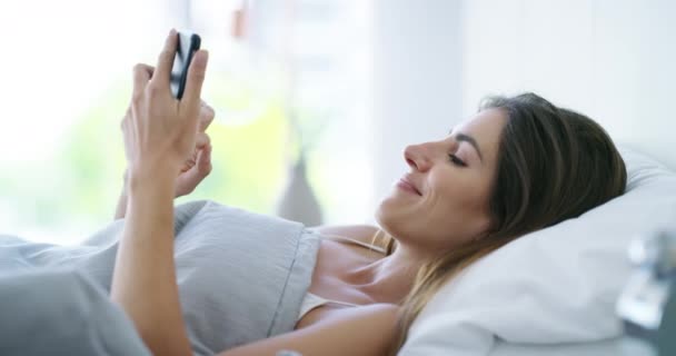 在床上开心地滚动电话 在家里看有趣的社交媒体通知 聊天或移动应用程序 早上在卧室里的手机 打字和搜索迷因 联系和下载网络 — 图库视频影像