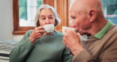 Yaşlı, çift ya da huzur evinde aşk bağı için çay sohbeti, emekliler birlikte rahatlar ya da sabah rutini. Erkek, kadın ve sıcak içecek kanepede güven destek iletişimi, evlilik sakin ya da mutlu barış.