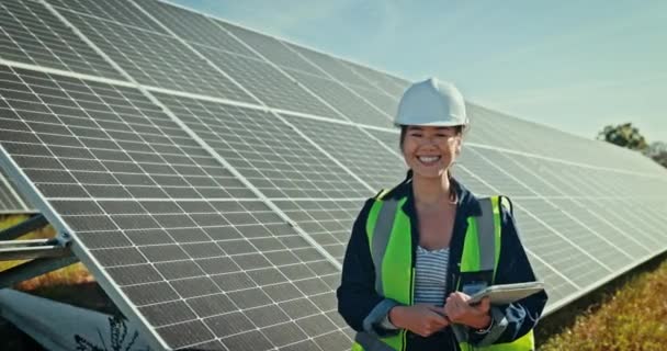 環境に優しい環境または自然の再生可能エネルギーのためのタブレットが付いている幸せな女性 エンジニアおよび太陽電池パネル 屋外の電気取付けのための技術の女性の人工技術者の肖像画 — ストック動画
