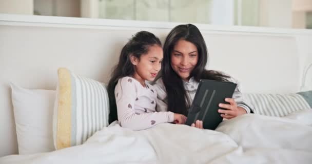 オンラインゲームのためのベッドでタブレットを持つママ 子供と少女 マルチメディアをダウンロードし 電子ブックのストーリーを読む 自宅でデジタル漫画や映画をストリーミングするためのハッピーマザー コミュニケーション — ストック動画