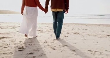 Seyahat etmek, el ele tutuşmak ve yazın romantizm için gün batımında sahilde yürüyen yaşlı bir çift. Okyanusu ya da denizi işaret eden yaşlı bir adam ve kadınla sırt, doğa ya da özgürlük.