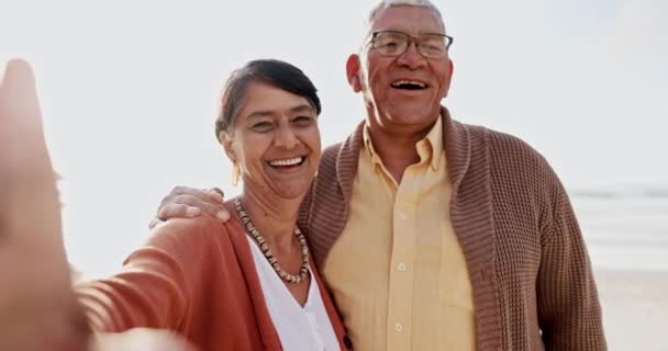 シニアカップル ビーチセルフィー またはメキシコでの休暇のための夏の日差しで結合に満足しています 高齢の女性 老人は 波による記憶のための写真で顔に笑顔 — ストック動画