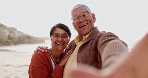 ハッピーシニアカップル ビーチセルフィー メキシコでの休暇のためのケア ボンディング 夏の日差しでハグ 高齢の女性 老人は 波による記憶のための写真で顔に笑顔 — ストック動画
