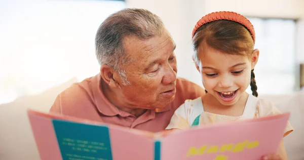 Happy grandfather, child and reading book on sofa for literature, education or bonding together at home. Grandparent with little girl smile for story, learning or relax on living room couch at house.