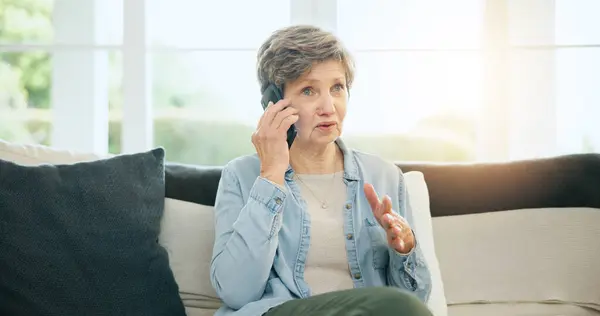 Senior, woman and phone call talking on sofa for communication, gossip or cell information. Old person, mobile device and speaking or technology network or connection, secret discussion or relax chat.