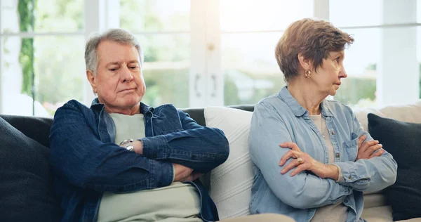 Senior, couple and stress with divorce and fight on sofa in living room of home with anger and silence. Elderly, man or woman with argument, upset and frustrated on couch in lounge of house or ignore.