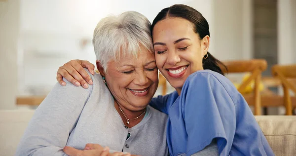 Happy woman, nurse and hug in elderly care for support, trust or love on living room sofa at old age home. Face of female person, doctor or medical caregiver hugging senior patient in relax at house.