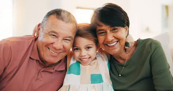 Grandparents, grandchild and smile in family portrait, love and picture for memory, hug and bonding. Happy mexican people, care and relax on couch, generations and connection at home, joy and embrace.