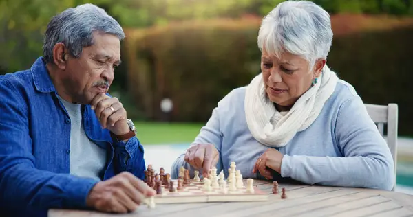 Senior couple, chess match or thinking of strategy, plan or mindset for brain power or move at home. Elderly woman, old man or board game for problem solving, ideas or challenge to relax in backyard.