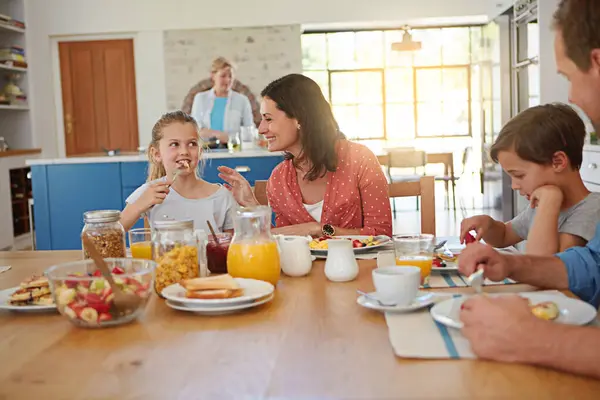 Food, breakfast and smile with a family at a dining room table in their home together for health or nutrition. Brother, sister and parents eating a meal in their apartment for love or morning bonding.
