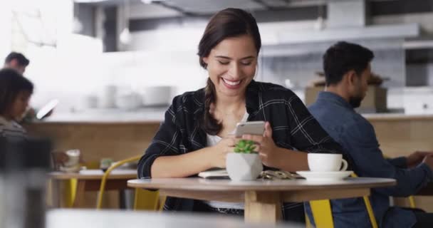 ソーシャルメディアのコーヒーショップで笑い 幸せな女性は インターネットやウェブサイトの通知でチャットします モバイルアプリ 笑顔やカフェのテキストで人 オンライン入力や面白いミームジョークを読む — ストック動画