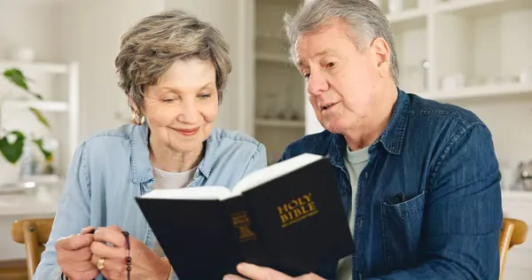 Bible study, reading and senior couple in home with Christian worship, prayer and education in faith. Elderly, people and studying holy gospel, religion or trust in God and together in retirement.