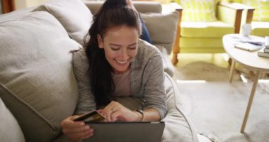 Kadın, kanepe ve tablet. Evde internet alışverişi, dijital ödeme ve fintech için kredi kartı var. Gençler koltukta e-ticaret, web sitesi aboneliği ya da kredi başvurusu ile rahatlayın.