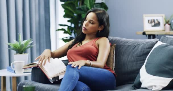 在沙发上看书或思考 在客厅里沮丧或困惑于叙事 年轻人 小说中的焦虑或困惑 在公寓沙发上的沉思或放松 — 图库视频影像