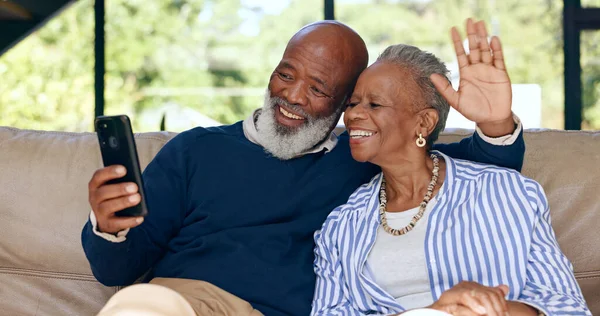 Video call, happy senior couple and phone in home for voip communication, social network or chat. African man, woman or wave hello on smartphone in virtual conversation, contact or talk in retirement.