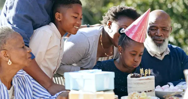 Child, cake or black family in nature for a happy birthday, celebration or support with grandparents. Candles, blow or excited African people with gift, love or kids in a fun party, backyard or park.