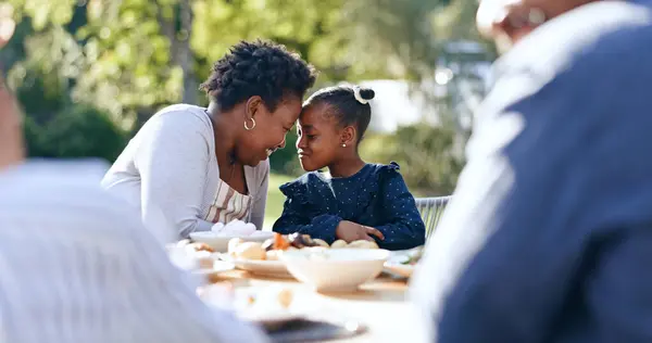 Smile, mother and daughter with forehead touch at garden lunch, nature and vacation together with love. Black people, woman or child with happy family, reunion and care for thanksgiving in park.