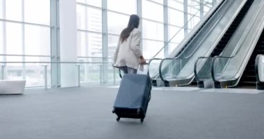 Kadın, havaalanında yürüyen ve yürüyen merdiven, merdiven ve iş adamları uçuş terminalinde, lobide ya da dinlenme odasında bavulla gezen. Koşmak, geç kalmak ve acele etmek, acele etmek ya da hızlı bir yolculuk yapmak..