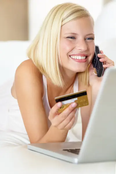 ラップトップ クレジットカード 家庭でのオンラインショッピングの支払いを持つ幸せで女性 リビングルームでの取引 オファー インターネット販売のための携帯電話ディスカッションでソファー上のEコマース クラムと少女 — ストック写真