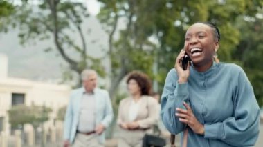 Siyahi bir kadın, iş için telefon görüşmesi ve şehir dışında yürümek, iletişim kurmak ve gülümsemeyle sohbet etmek. Cep telefonlu, ağaçlı ve işe gidip gelme konusunda tartışan mutlu iş kadını.