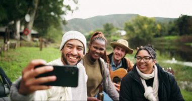 Selfie, kamp ve orman gölünde arkadaşlar, mutlu ve doğada gitar ve içeceklerin tadını çıkarıyorlar. Akıllı telefon, profil fotoğrafı ve bir grup insan ormanda rahatlar, eğlenir ve özgürlüğün tadını çıkarırlar..