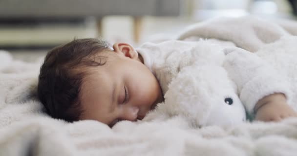 かわいい 平和で 赤ちゃんは 家庭のリビングルームでの快適さのために毛布の上に寝ています 愛らしい 女の子の赤ちゃんは 休憩のために昼寝を取るか リラックスしたり 現代の家で夢を見ます — ストック動画