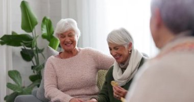 Arkadaşlar, sohbet ve kanepede sosyal ziyaret, kaynaşma ve birlikte kaliteli zaman geçirmek için yaşlı kadınlar. Arkadaşlık, emeklilik ve evde sohbet eden mutlu yaşlılar, gülmek ve çay eşliğinde eğlenmek..