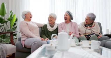 Arkadaşlar, sohbet ve sosyal ziyaret, kaynaşma ve kaliteli zaman geçirmek için kanepede oturan yaşlı kadınlar. Arkadaşlık, emeklilik ve mutlu yaşlılar evlerinde çayla sohbet ediyor, gülüyor ve eğleniyorlar..