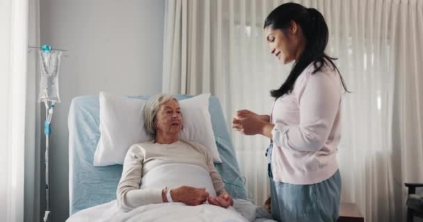 高齢者ケアの女性 看護師 患者は 病院で医療支援のためにベッドで治療を受けています 女性ボランティア 介護者または医師は 診療所で回復するために高齢者薬や薬を与える — ストック動画