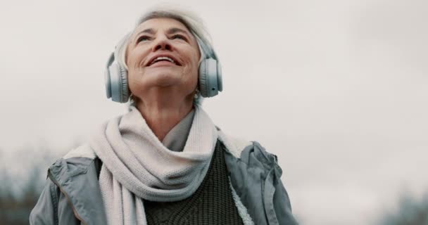 老妇人 带着耳机和室外音乐思考 散步和健康 有声流淌 精力充沛 Podcast 听广播 听广播 听广播 听广播 — 图库视频影像