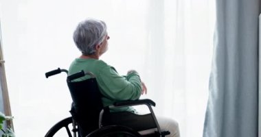 Yaşlı, kadın ve evde tekerlekli sandalyede oturup emeklilikte engelli birinin rahatlaması. Düşünceli, hafızalı ve yaşlı bir kadın yalnızlıkla pencerede oturuyor veya bir rüyayı hatırlıyor.
