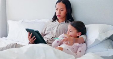 Anne, hasta çocuk ve video tavsiye için evde bir yatakta termometre ve tabletle bekliyor. Endişeli kadın yatak odasında bir kızla çevrimiçi danışmanlık, tele sağlık ve internet sağlığıyla ilgili sağlık sorunları.