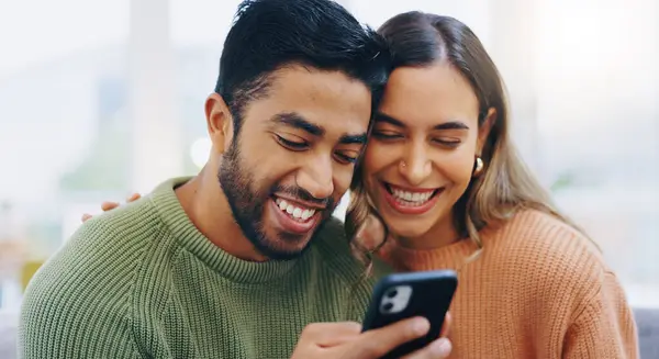 Couple, living room couch and happy with phone, smile and click for contact, meme and notification in home. Man, woman and texting with smartphone, reading and app for social network, video and relax.