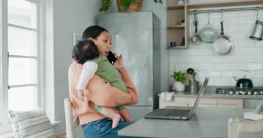 Telefon görüşmesi, uzaktan çalışma ve serbest girişimci olarak çalışırken bebeğini oturma odasında tutan bir anne. Dizüstü bilgisayar, yeni başlayanlar ve tek ebeveynler ve küçük çocuğu mutfakta..