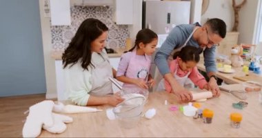 Mutlu ebeveynler çocuklara mutfak tezgahında birlikte yemek yapmayı öğretiyor. Tatlıyı bir beceri olarak hazırlıyorlar. Gelişme, anne ve baba çocuklara kurabiye tarifi ya da yemek konusunda yardım ediyor.