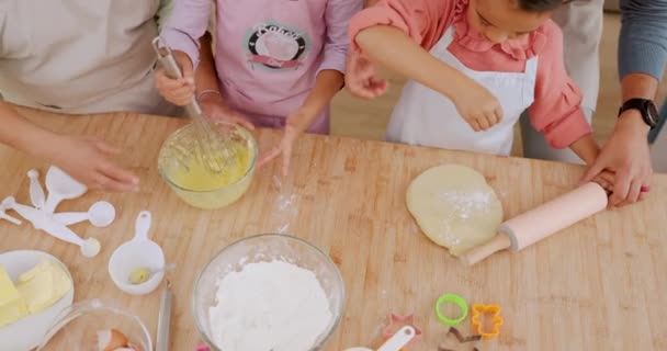 家庭のキッチンカウンターで両親と一緒に焼く学習 子供たちは上からデザートを調理します 父親は クッキーのレシピや食べ物を子供たちに教えるか 助ける — ストック動画